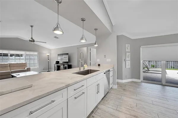 a large kitchen with kitchen island a counter space a sink a window and stainless steel appliances
