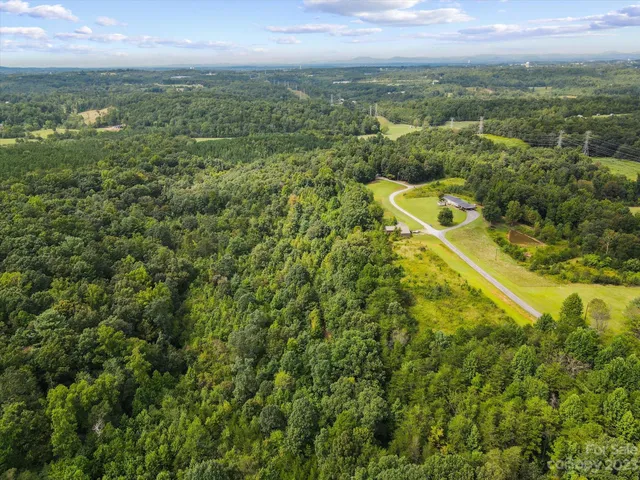 an aerial view of residential houses with outdoor space and trees