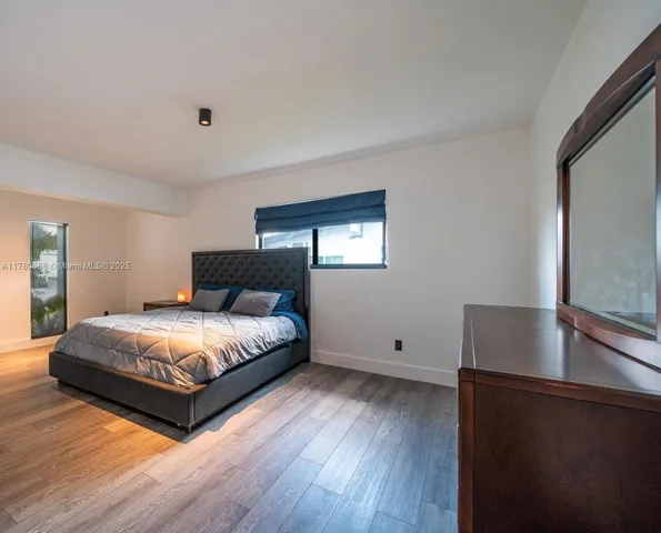 a bedroom with a bed and a night stand