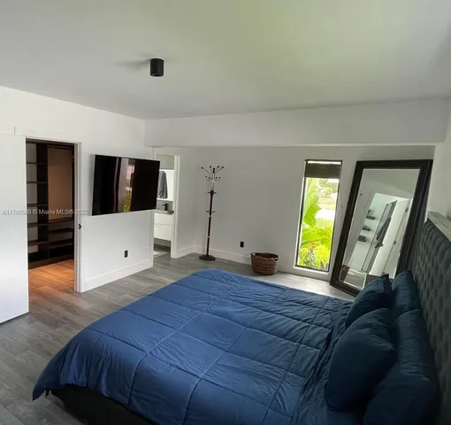 a bedroom with a bed and a large window