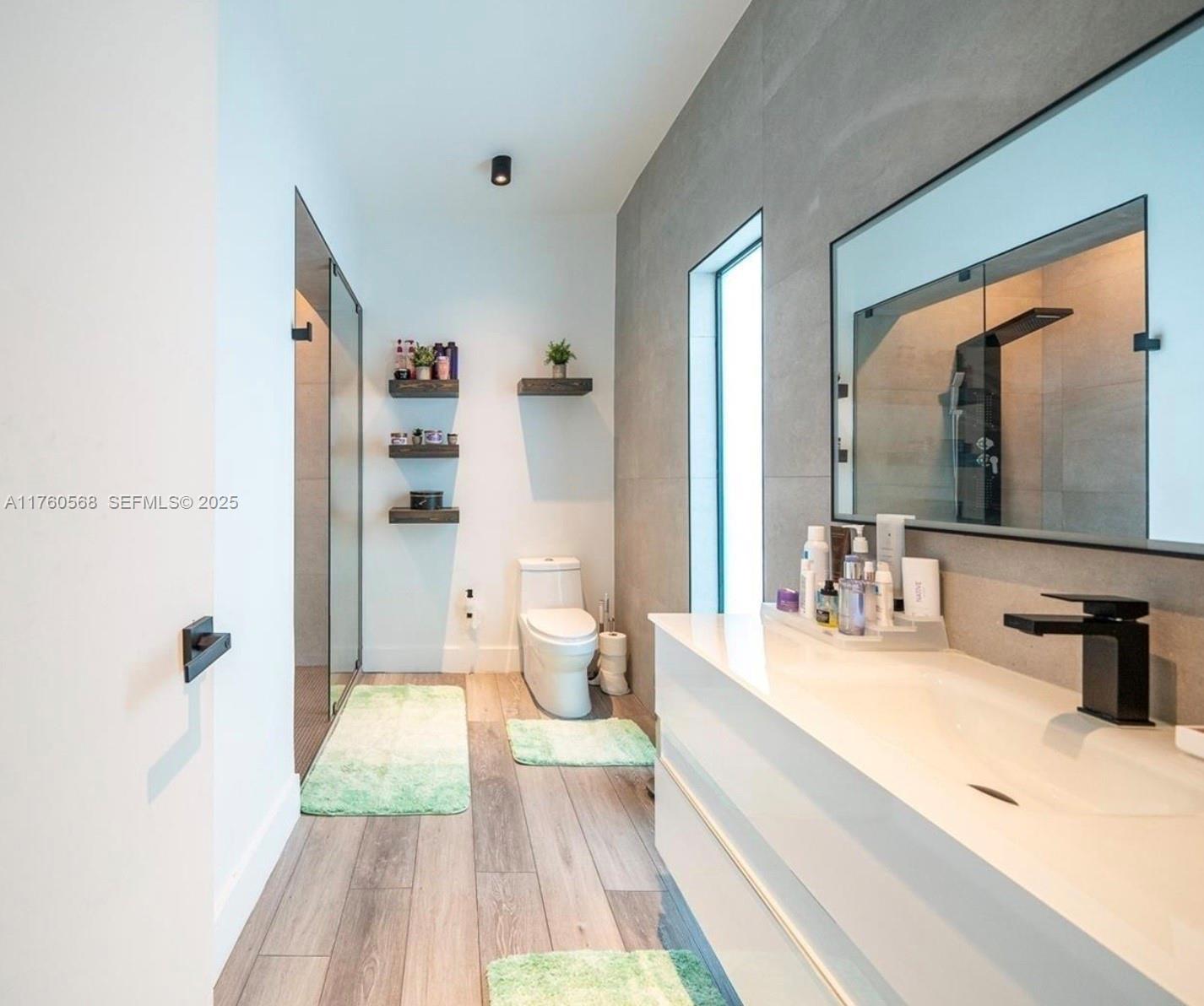 19600 Northeast 19th Avenue Miami, FL 33179 - Photo 17 of 33 a spacious bedroom with a bed and a large mirror