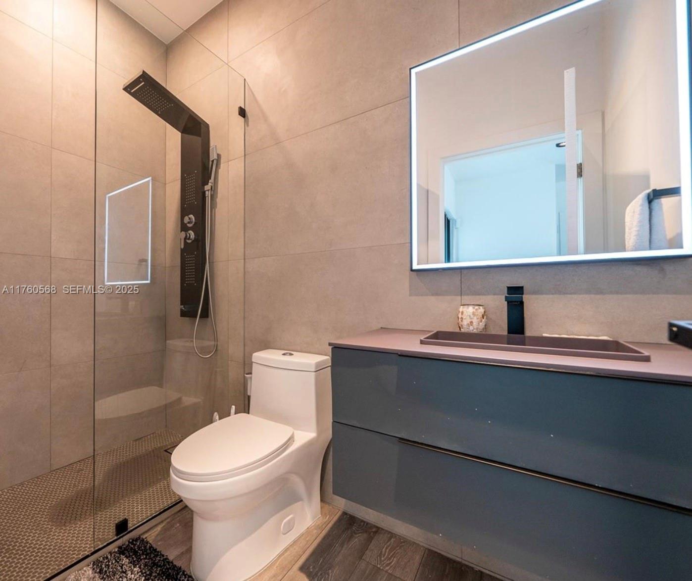 19600 Northeast 19th Avenue Miami, FL 33179 - Photo 25 of 33 a bathroom with a sink a toilet and shower