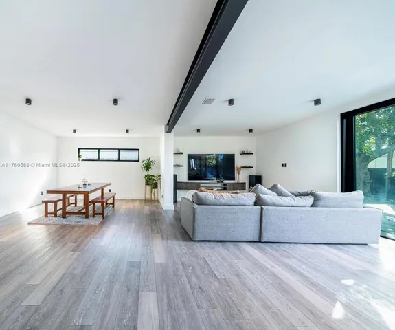 a living room with furniture and a wooden floor