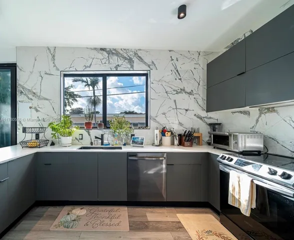 a kitchen with stainless steel appliances a sink a stove and a window