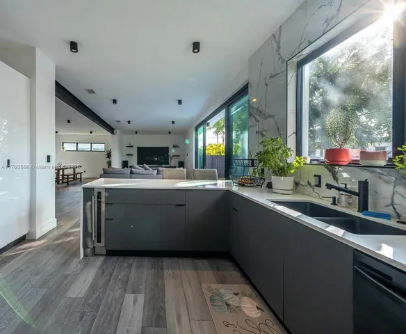 a kitchen with stainless steel appliances granite countertop a sink and wooden cabinets
