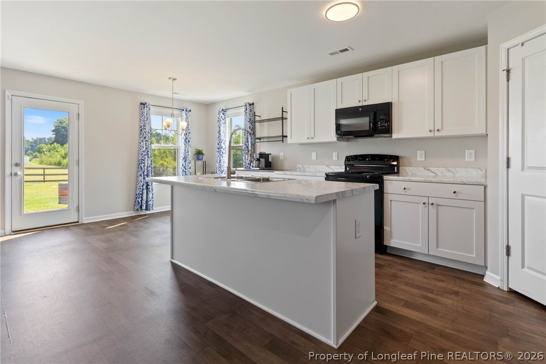 1368 Talmage Road St. Pauls, NC 28384 - Photo 6 of 26 a kitchen with stainless steel appliances granite countertop a sink a stove a microwave a refrigerator a window
