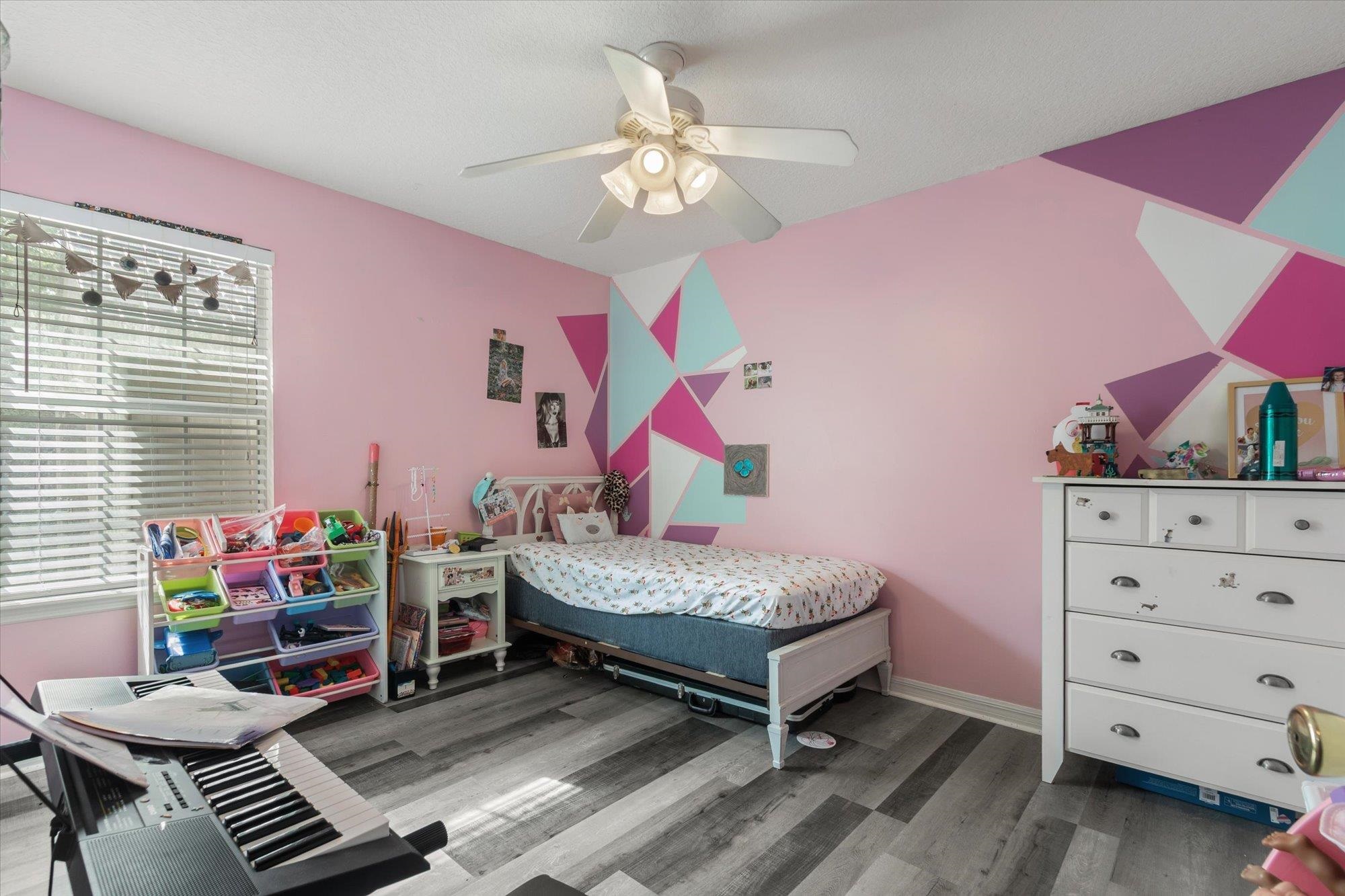 3372 4th Street Elkton, FL 32033 - Photo 12 of 36 a bedroom with a bed and a chandelier