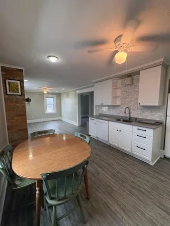 a kitchen with a table chairs sink and cabinets