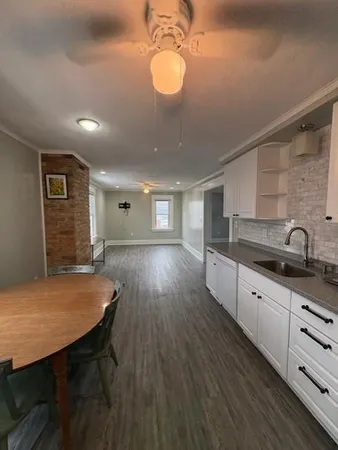 a kitchen with stainless steel appliances granite countertop a sink dishwasher and cabinets with wooden floor