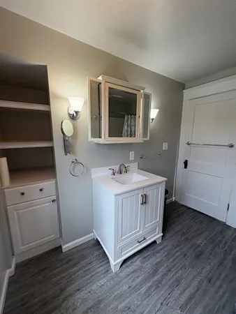 a bathroom with a granite countertop double vanity sink and mirror