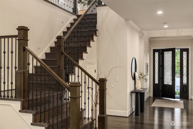 a view of staircase with lots of frames on wall and windows