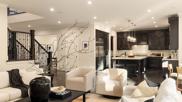 a living room with furniture kitchen view and a chandelier