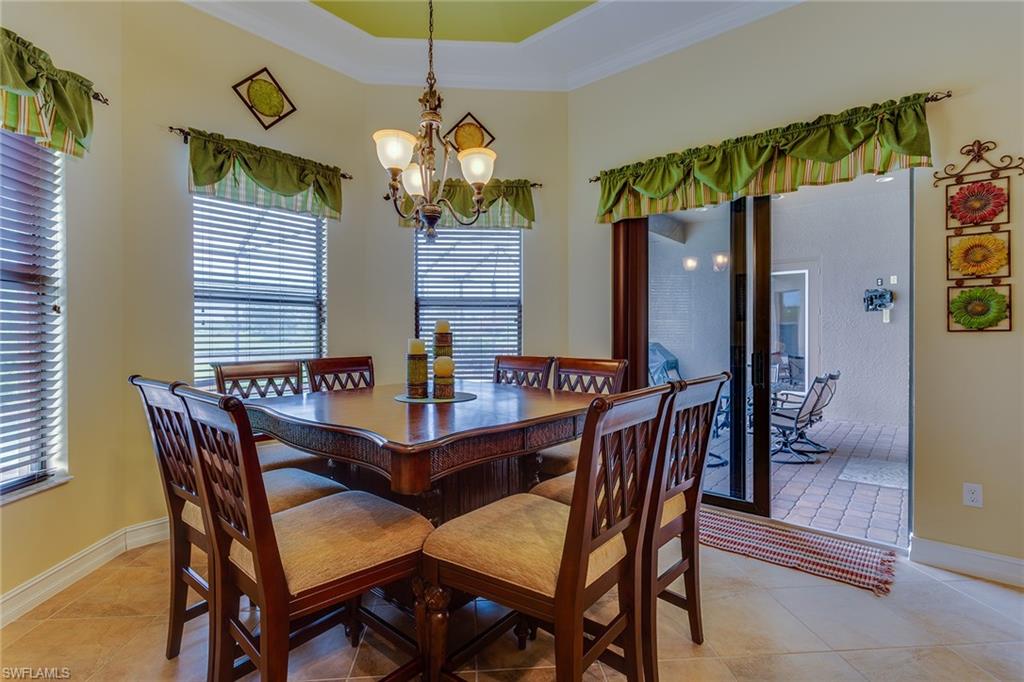 7771 Cottesmore Drive Naples, FL 34113 - Photo 11 of 32 a view of a dining room with furniture and chandelier