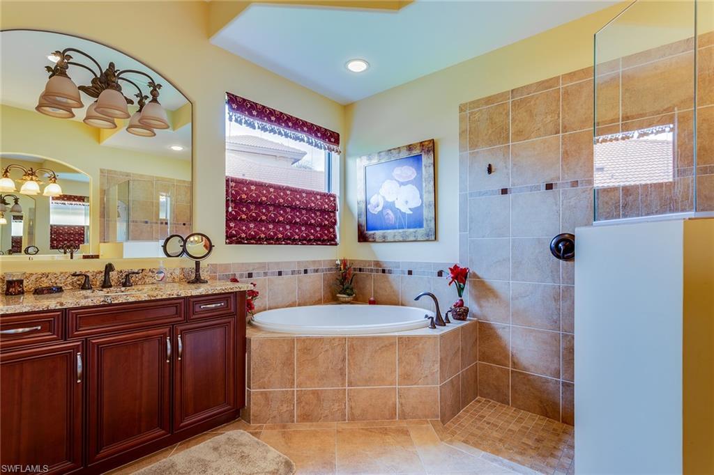7771 Cottesmore Drive Naples, FL 34113 - Photo 23 of 32 a bathroom with a tub sink and mirror