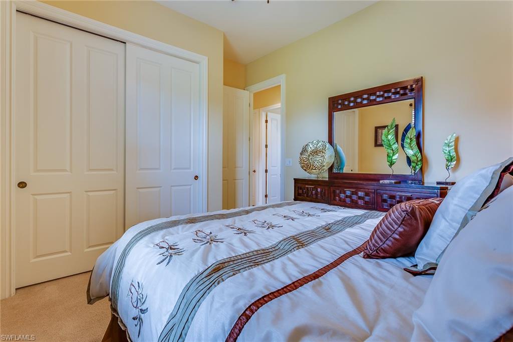 7771 Cottesmore Drive Naples, FL 34113 - Photo 27 of 32 a bedroom with bed and wooden floor