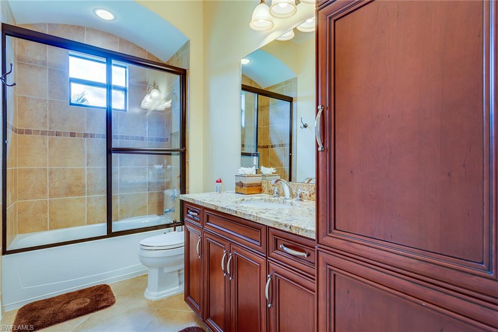 7771 Cottesmore Drive Naples, FL 34113 - Photo 28 of 32 a bathroom with a sink a toilet and mirror