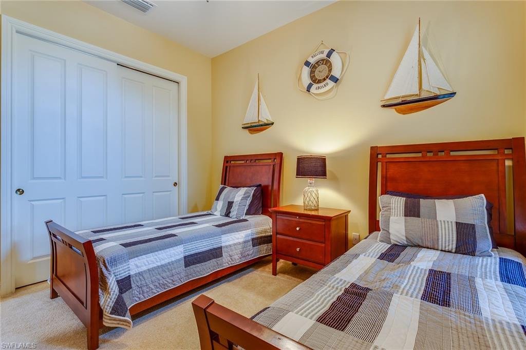 7771 Cottesmore Drive Naples, FL 34113 - Photo 29 of 32 a bedroom with a bed and wooden floor
