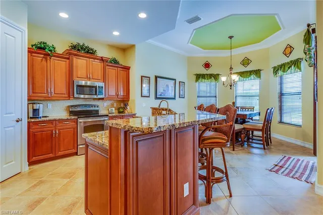 a kitchen with stainless steel appliances granite countertop a stove top oven a sink dishwasher and cabinets with wooden floor