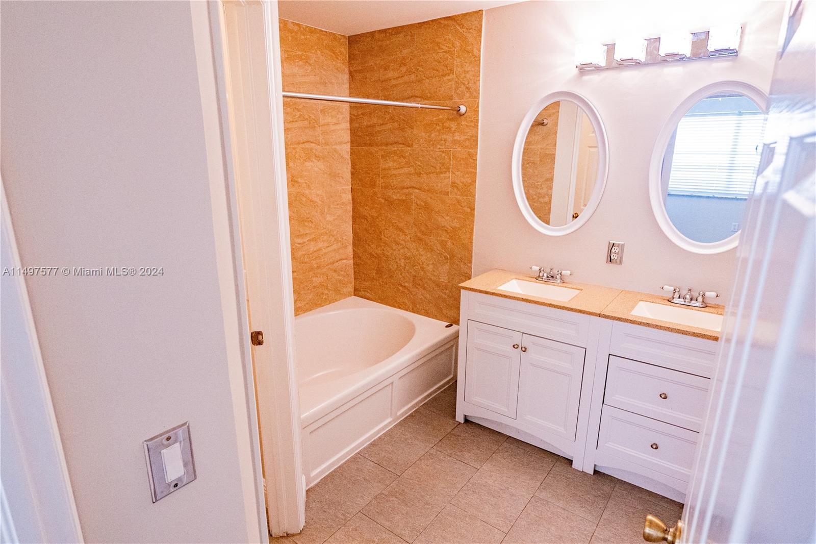 Shenandoah Davie, FL 33325 - Photo 23 of 61 a spacious bathroom with a double vanity sink a mirror and a bathtub