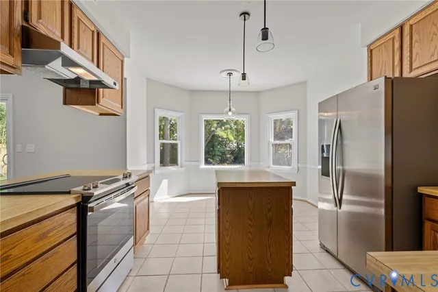 a kitchen with stainless steel appliances granite countertop a refrigerator and a stove