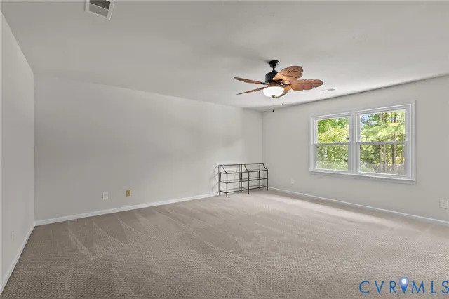 an empty room with fan and windows