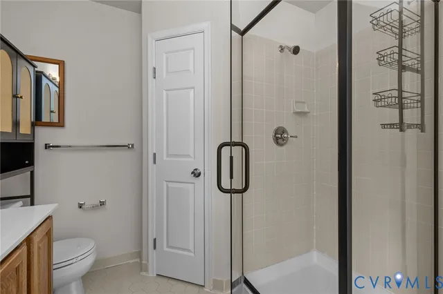 a bathroom with a granite countertop shower a toilet and sink