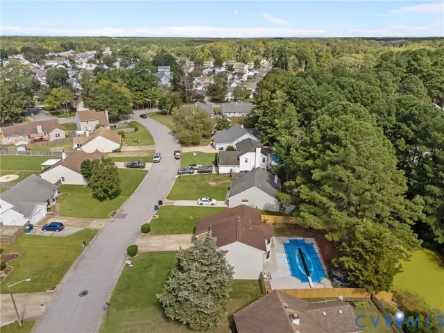 an aerial view of residential houses with outdoor space and trees