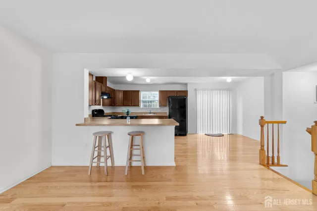 a large kitchen with stainless steel appliances kitchen island granite countertop a stove a refrigerator a sink dishwasher and a oven with wooden floor