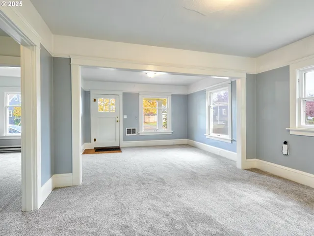 an empty room with windows and closet