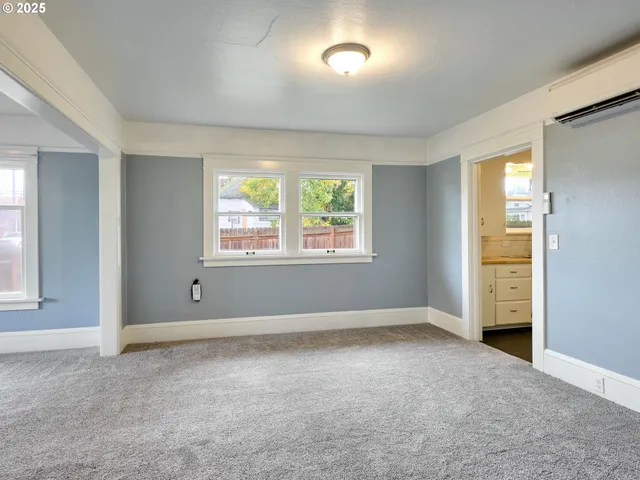 an empty room with windows and closet