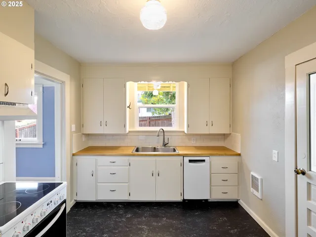 a utility room with cabinets washer and dryer