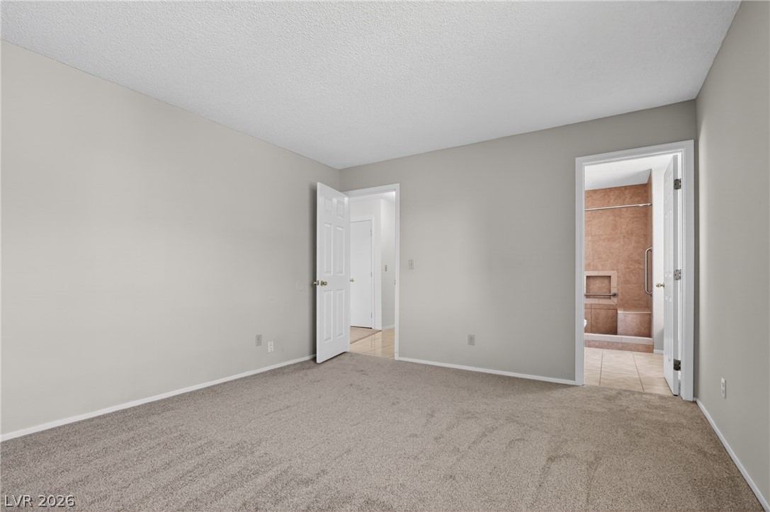 2241 Highpointe Drive, Unit 101 Laughlin, NV 89029 - Photo 16 of 23 This spacious room features neutral tones and soft carpeting, offering a peaceful retreat with private bath access.
