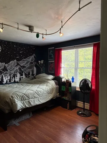 a bedroom with a bed and a large window