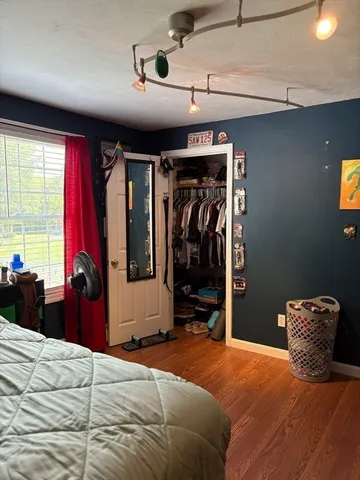 a bedroom with a bed and wooden floor