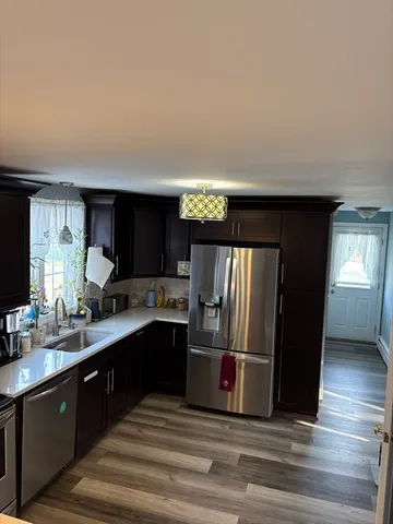 a kitchen with stainless steel appliances granite countertop a refrigerator and a sink