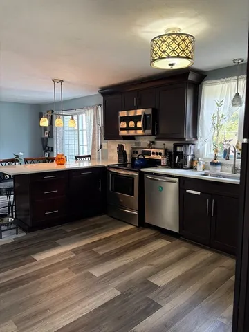 a kitchen with stainless steel appliances granite countertop a sink counter space cabinets and a window
