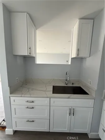 a kitchen with white cabinets and a sink