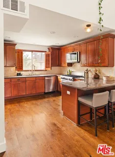 a kitchen with stainless steel appliances granite countertop a refrigerator and a stove top oven