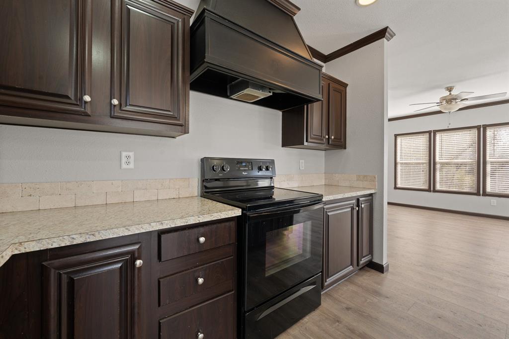 9419 Hilltop Street Rio Vista, TX 76093 - Photo 16 of 40 a kitchen with stainless steel appliances granite countertop a stove and a microwave