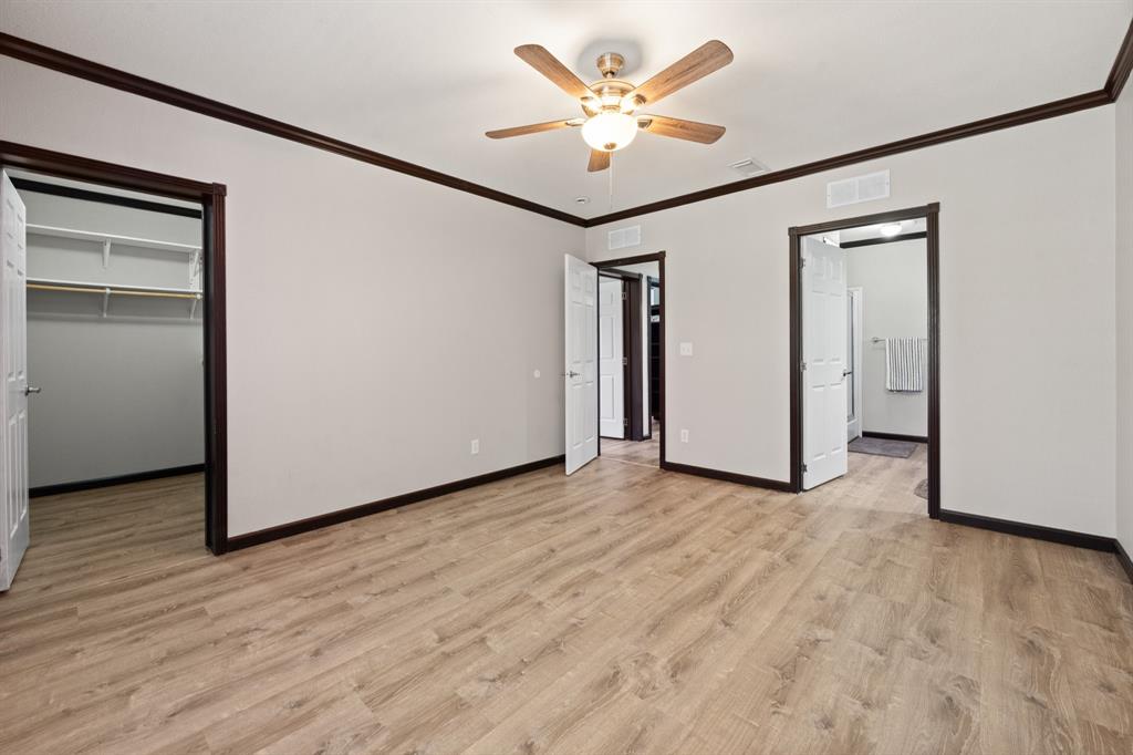 9419 Hilltop Street Rio Vista, TX 76093 - Photo 22 of 40 an empty room with wooden floor and ceiling fan