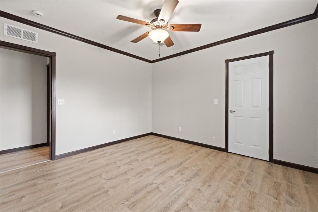 9419 Hilltop Street Rio Vista, TX 76093 - Photo 30 of 40 a view of a big room with wooden floor and a ceiling fan