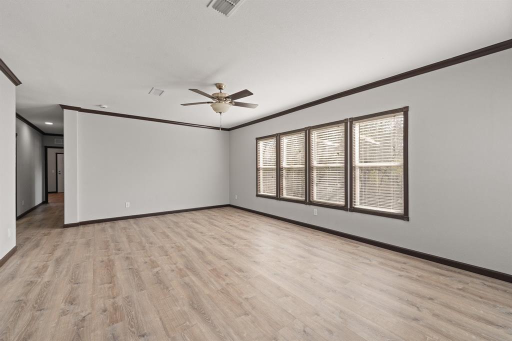 9419 Hilltop Street Rio Vista, TX 76093 - Photo 9 of 40 a view of an empty room with a window and wooden floor