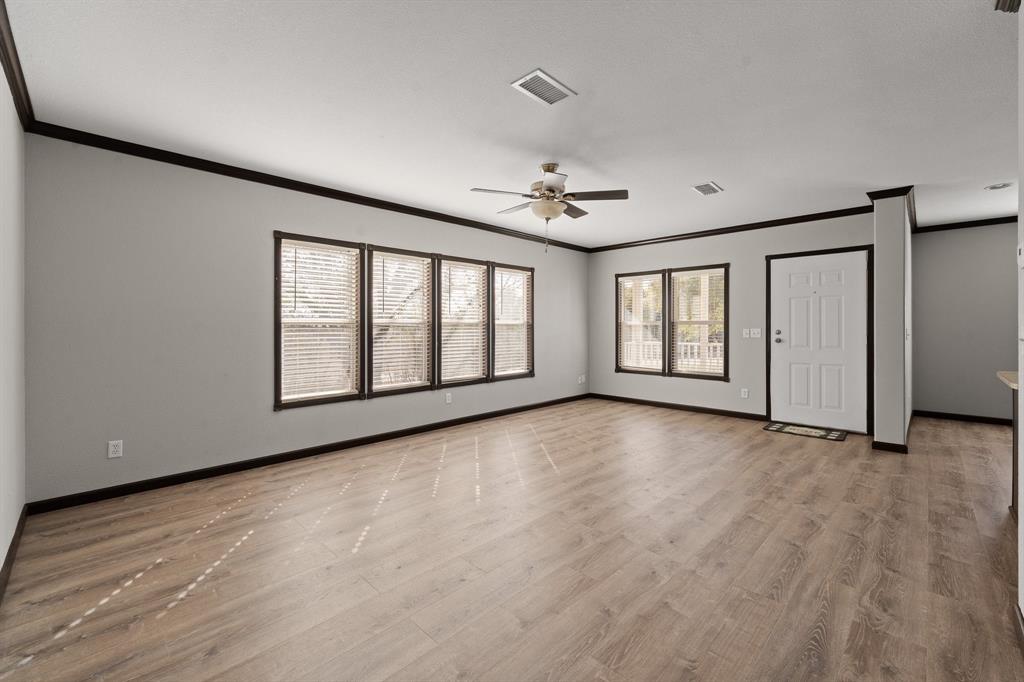 9419 Hilltop Street Rio Vista, TX 76093 - Photo 10 of 40 a view of an empty room with a window and wooden floor