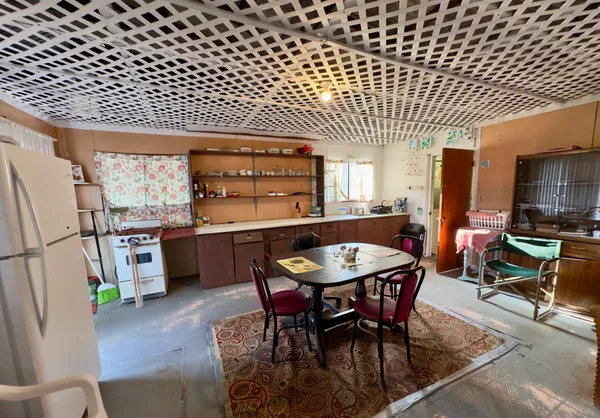 a dining area with a table chairs and a refrigerator