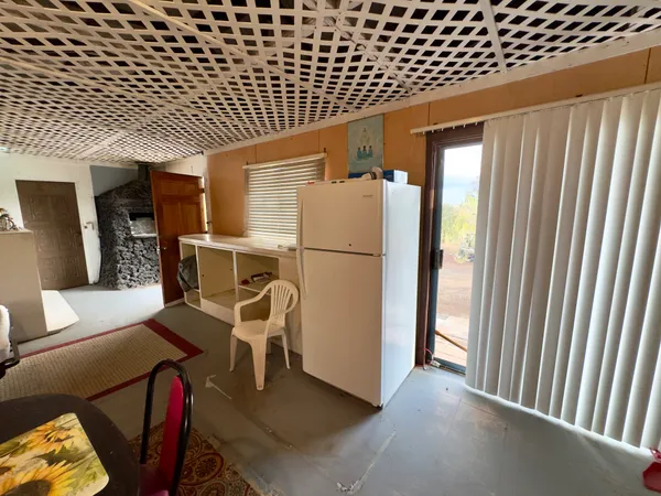 a view of a hallway with furniture and a refrigerator