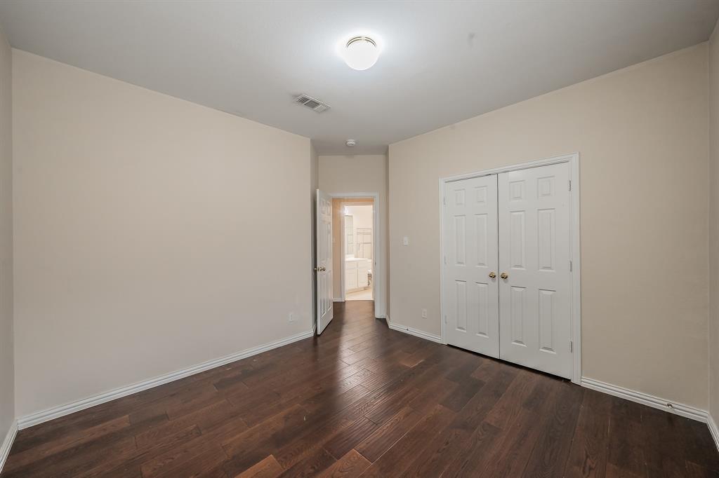 2306 Bear Run Road Arlington, TX 76001 - Photo 13 of 40 Unfurnished bedroom featuring a closet and dark wood-style floors