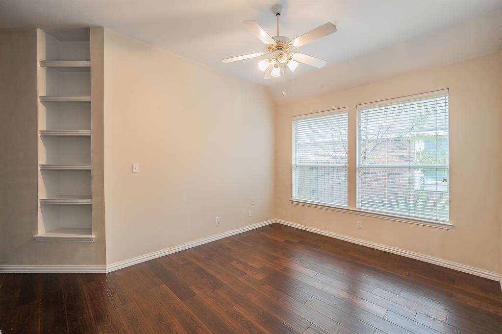 2306 Bear Run Road Arlington, TX 76001 - Photo 15 of 40 Empty room with dark wood-style flooring, a ceiling fan, and built in shelves
