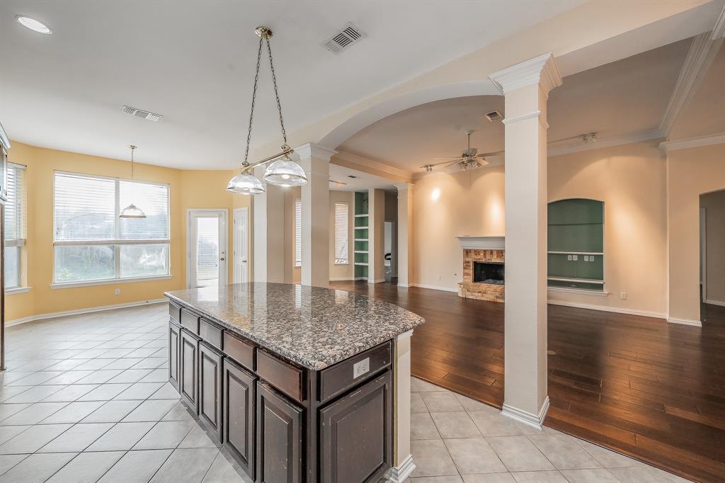 2306 Bear Run Road Arlington, TX 76001 - Photo 35 of 40 Kitchen featuring built in features, dark stone countertops, a fireplace, and arched walkways