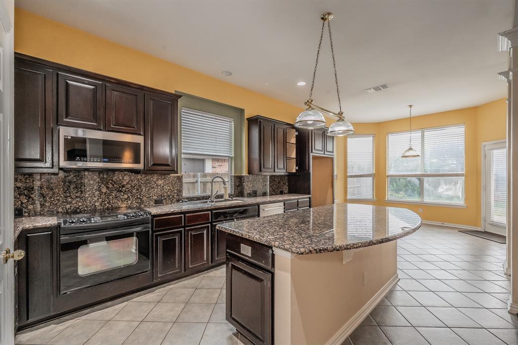 2306 Bear Run Road Arlington, TX 76001 - Photo 36 of 40 Kitchen with dark brown cabinetry, decorative backsplash, dark stone counters, black range with electric cooktop, and recessed lighting
