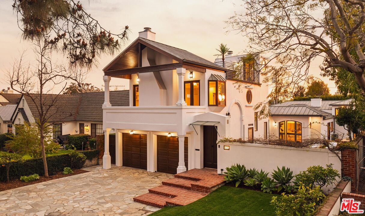 a front view of a house with a yard and trees